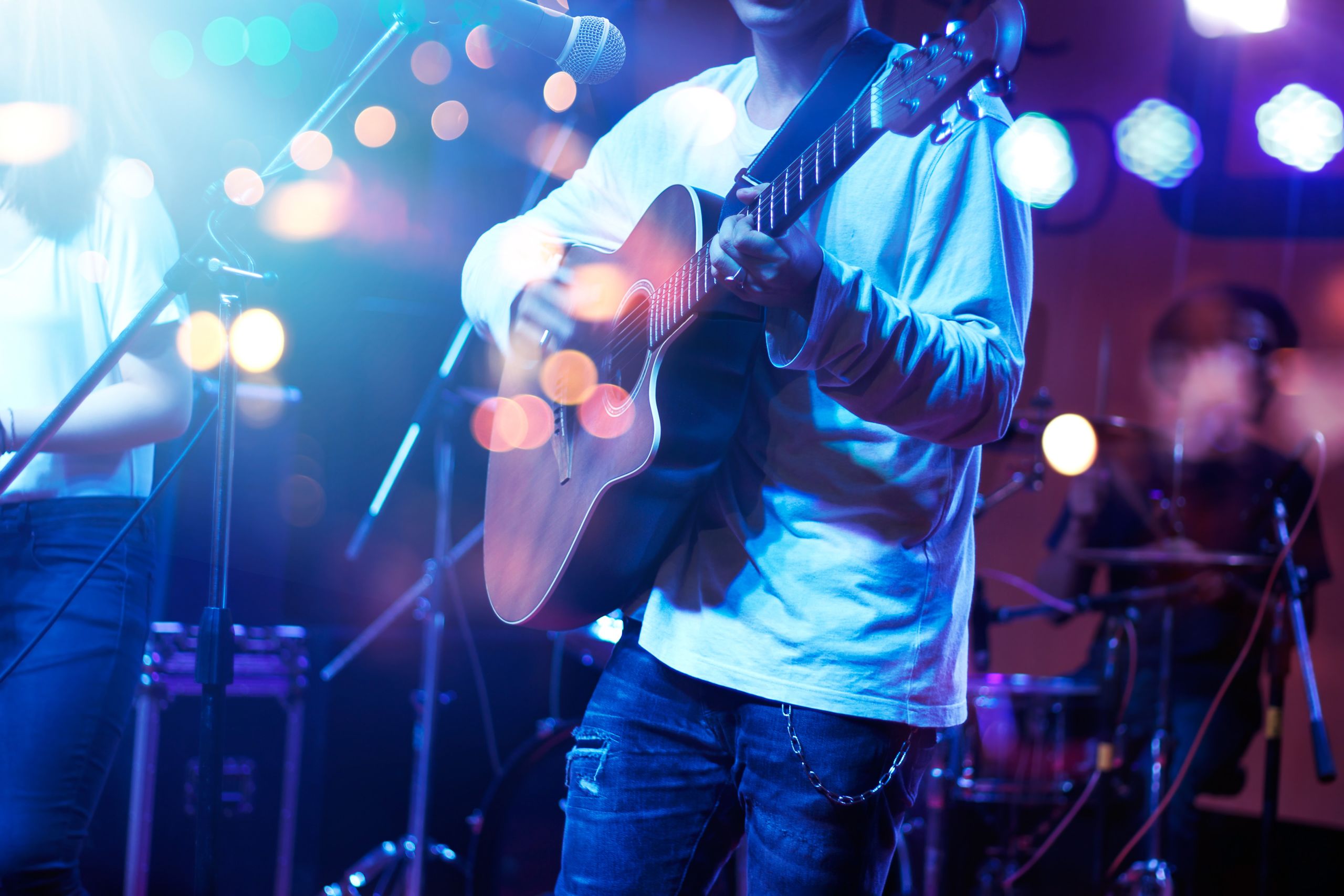 Image of a musician playing a guitar on stage