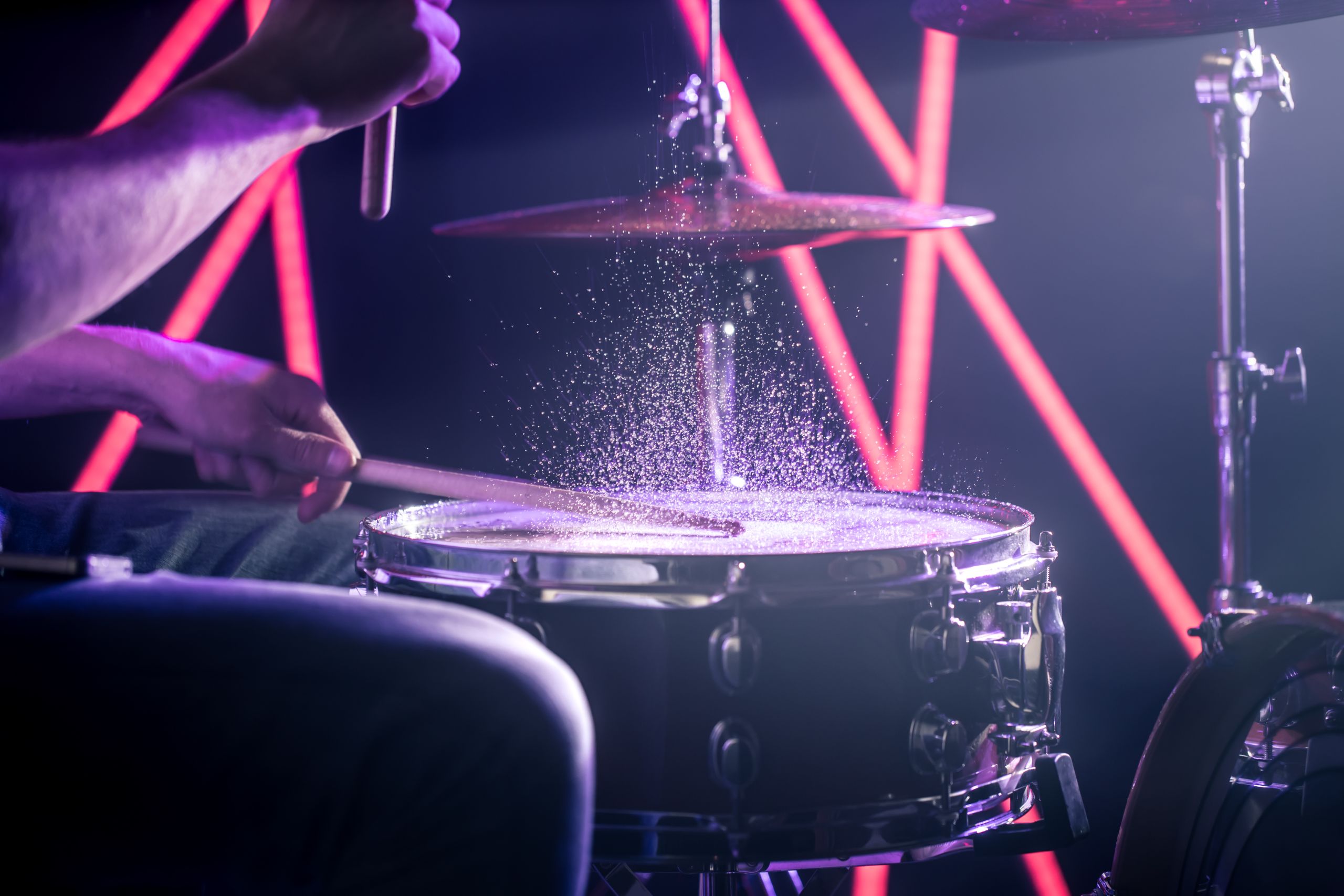 Background image of a musician playing the drums