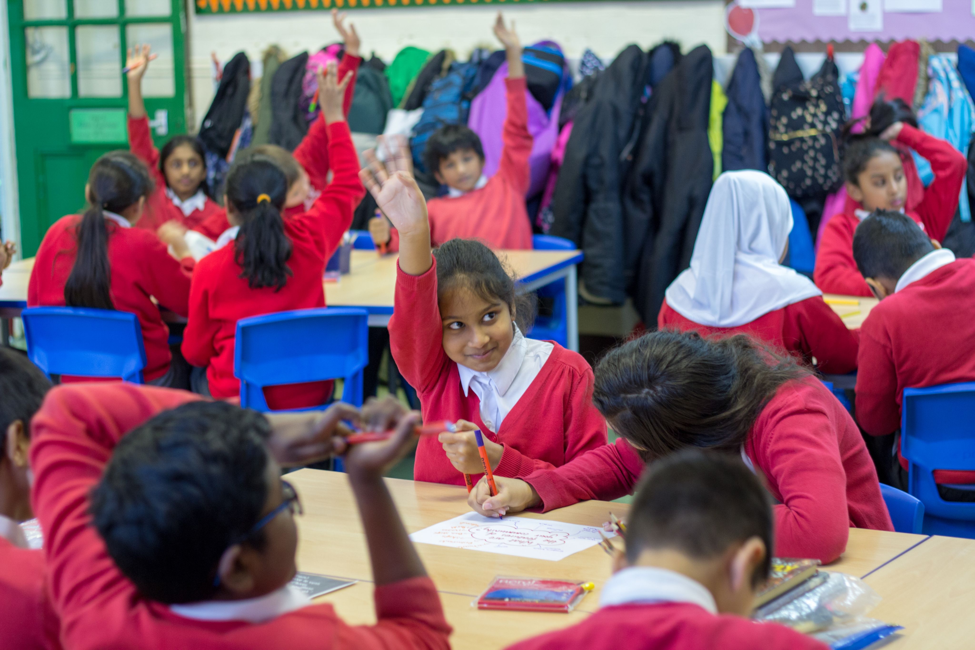 A young girl is putting her hand up